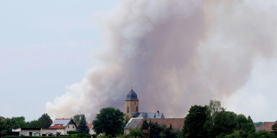 Rauch eines Waldbrandes steigt über dem Dorf Lichtensee (Landkreis Meissen) auf. Seit 23.06.2022 brennt es in der Gohrischheide.