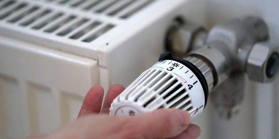 Eine Frau dreht an einem Heizungsthermostat. Die von der Bundesregierung geplante Entlastung vieler Mieter bei der Heizkosten-Klimaabgabe kommt voran.