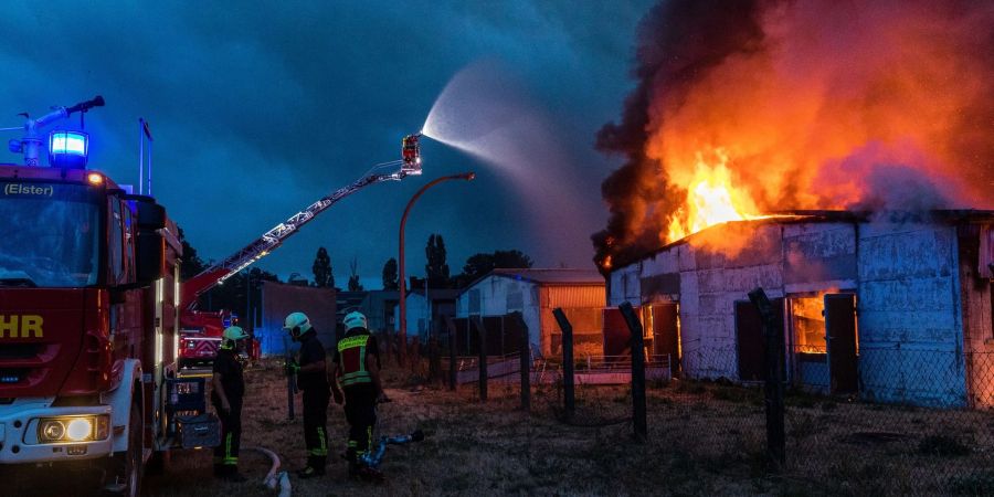 Einsatzkräfte der Feuerwehr versuchen, einen Gebäudebrand in der Region Falkenberg /Elster zu löschen.