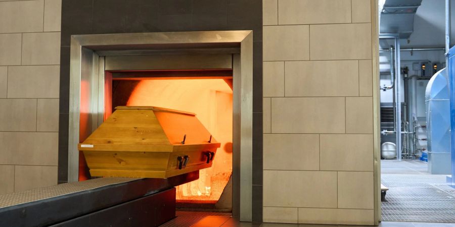 Ein Sarg fährt im Krematorium in Dachsenhausen bei Koblenz in die Brennkammer ein.