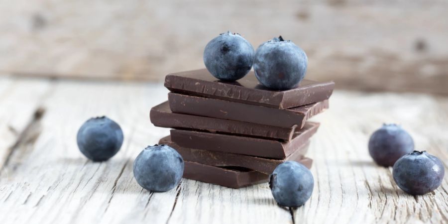 Dunkler Schokoladenstapel und Blaubeeren.