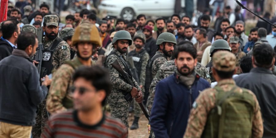 ARCHIV - Sicherheitskräfte sind nach einem Anschlag auf ein schiitisches Gemeindehaus vor Ort und kontrollieren eine Menschenmenge. Foto: Anjum Naveed/AP/dpa