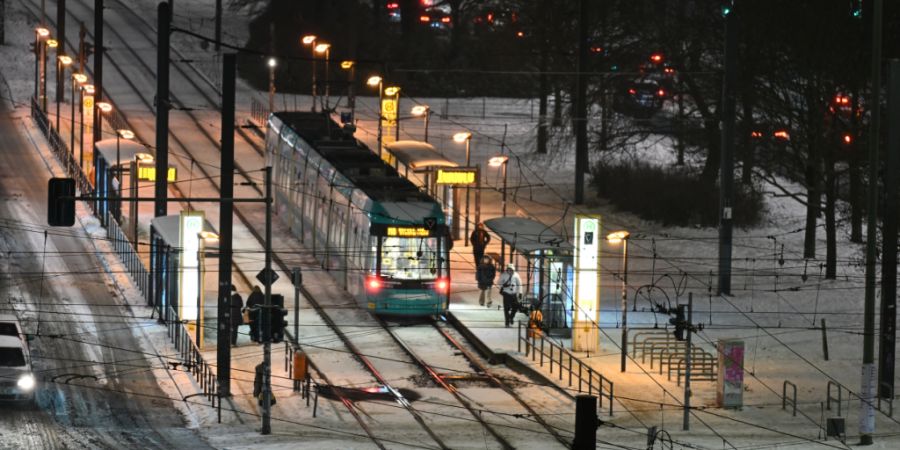 ARCHIV - Nahe des Alexanderplatzes liegt noch Schnee auf den Straßen und zwischen den Schienen, während eine Tram kommt und Fußgänger unterwegs sind. Foto: Annette Riedl/dpa