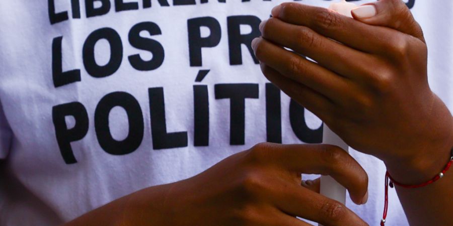 Eine Frau hält eine Kerze bei einer Demonstration für die Freilassung von politischen Gefangenen in der Nähe des Gefängnisses El Helicoide. Foto: Javier Campos/dpa