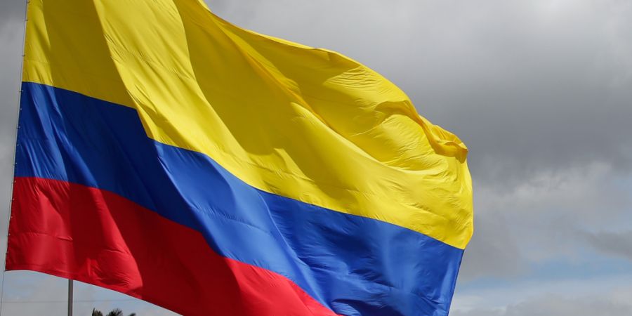 ARCHIV - Eine kolumbianische Fahne weht am «Tag der Helden», bei einer Militärparade in Bogota. In Kolumbien hat es ein schweres Busunglück mit mehreren Toten gegeben. Foto: Luisa G...