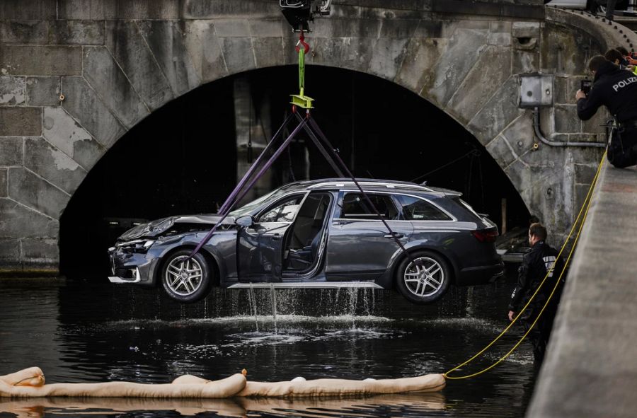 Rettungskräfte bergen einen Personenwagen neben der Münsterbrücke aus der Limmat, am 5. November 2021 in Zürich.