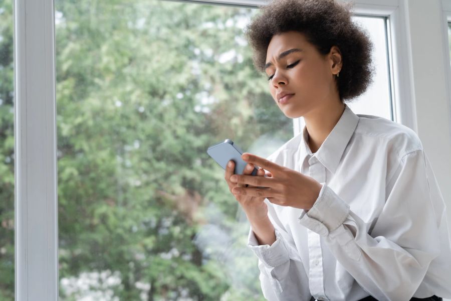 frau schaut auf handy, grüner hintergrund