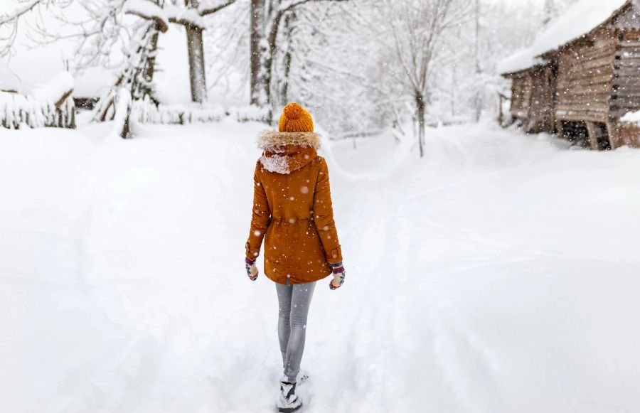 Mädchen geht im Schnee spazieren.