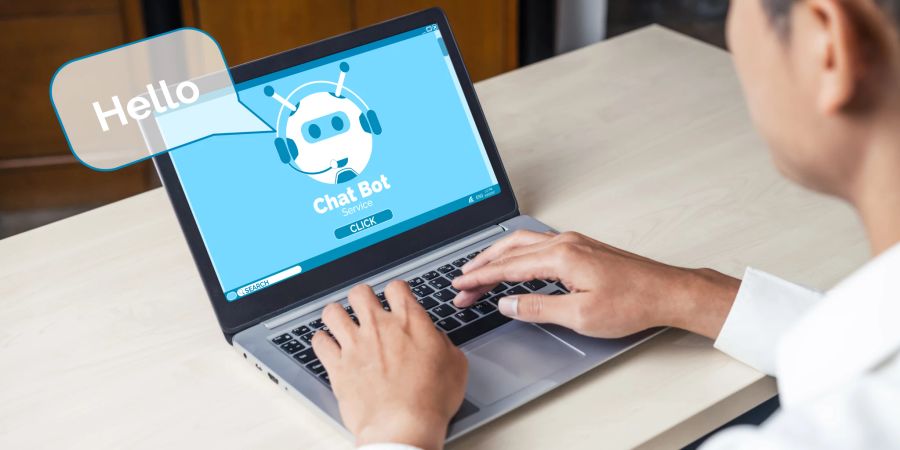 Mann nutzt Chatbot am Laptop