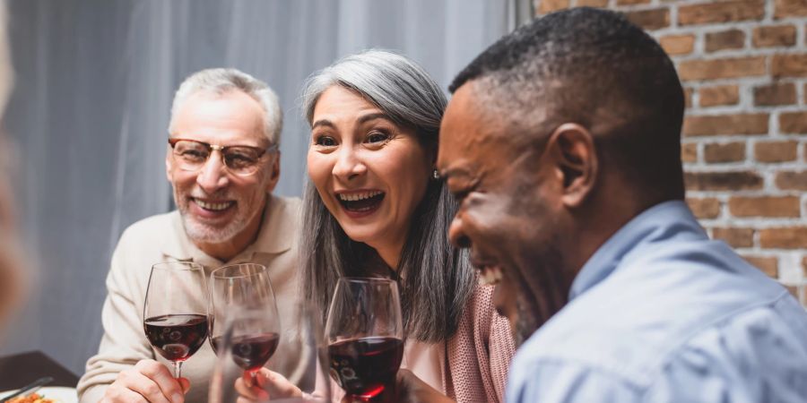 freunde lachen gemeinsam am tisch sitzend