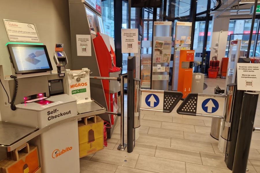 Eine andere Methode der Migros: Die sogenannten Schwenkarme öffnen erst dann, wen man bei der Säule ganz rechts im Bild den Barcode des Kassenzettels scannt.
