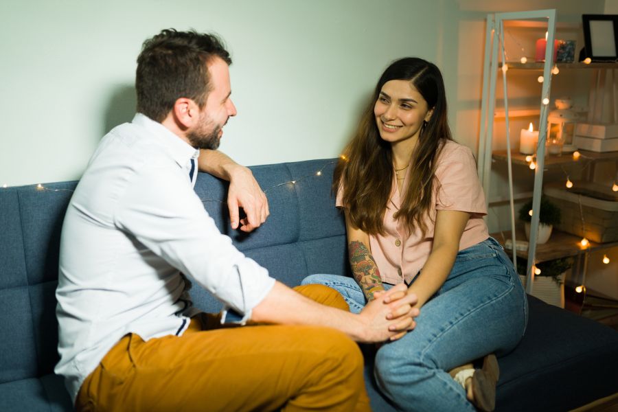 Date, Mann und Frau halten Hände auf einem Sofa