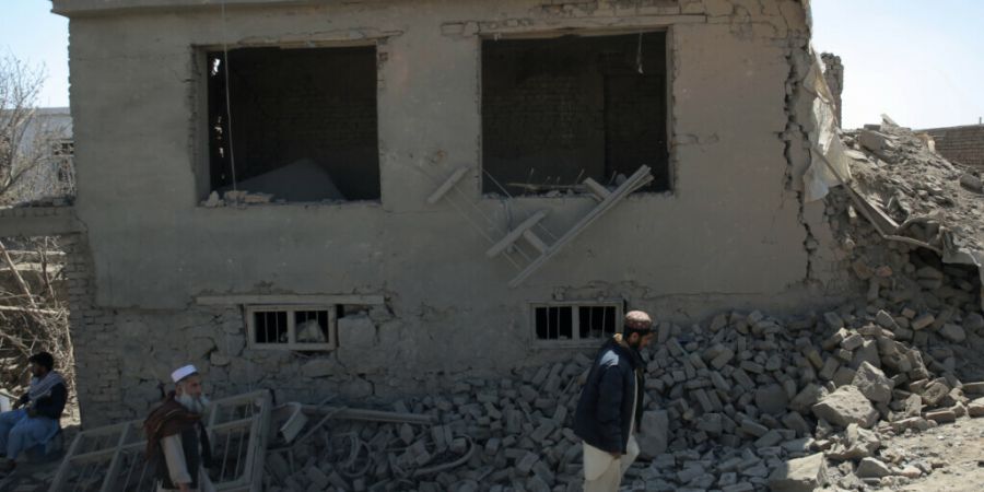 ARCHIV - Menschen gehen inmitten der Zerstörung, die ein pakistanischer Luftangriff in der Nacht am Stadtrand angerichtet hat. Foto: Sami Jan/dpa