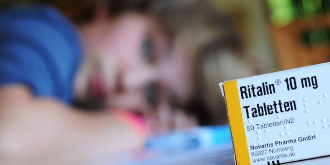 Eine Packung des Medikaments Ritalin des Herstellers Novartis steht auf einem Tisch, an dem ein zehnjähriger Junge seine Hausaufgaben erledigt. ADHS Ritalin
