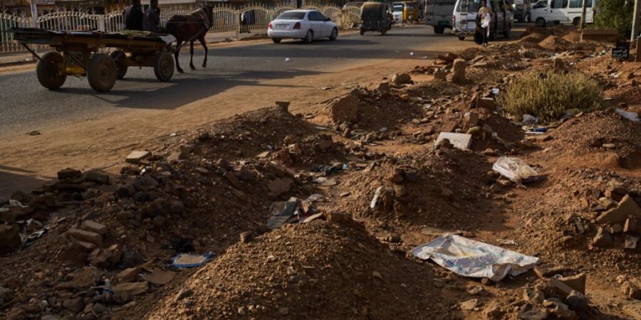 ARCHIV - Gräber reichen auf den Bürgersteig einer Straße in Omdurman, am Rande von Khartum. Foto: Bernat Armangue/AP/dpa