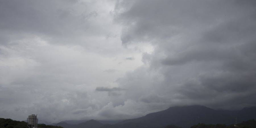 Dunkle Wolken hängen über Bergen und Gebäuden am Stadtrand. Taiwan bereitet sich auf den Taifun «Bavi» vor. Foto: Andre M. Chang/ZUMA Press Wire/dpa