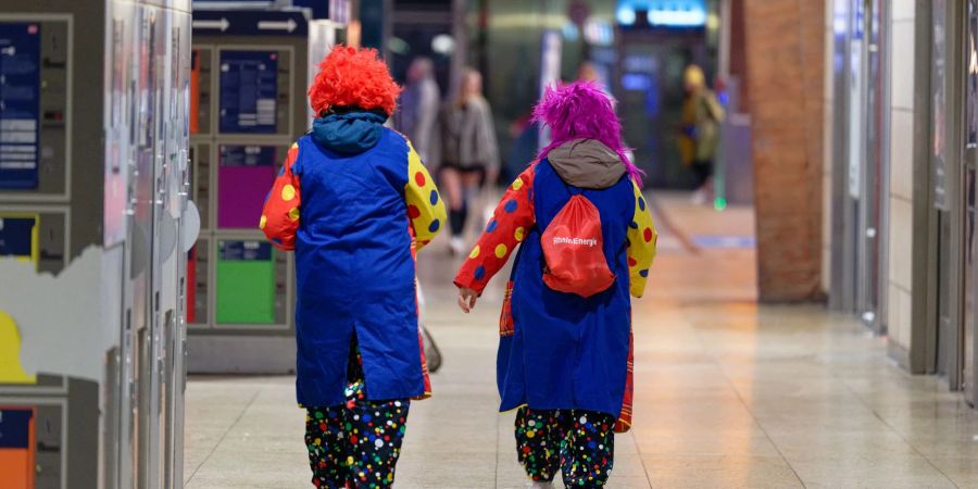 Kölle Allaaf um sieben Uhr: Zum 11.11. mischen sich so manche Clowns unter die Pendler am Kölner Hauptbahnhof.