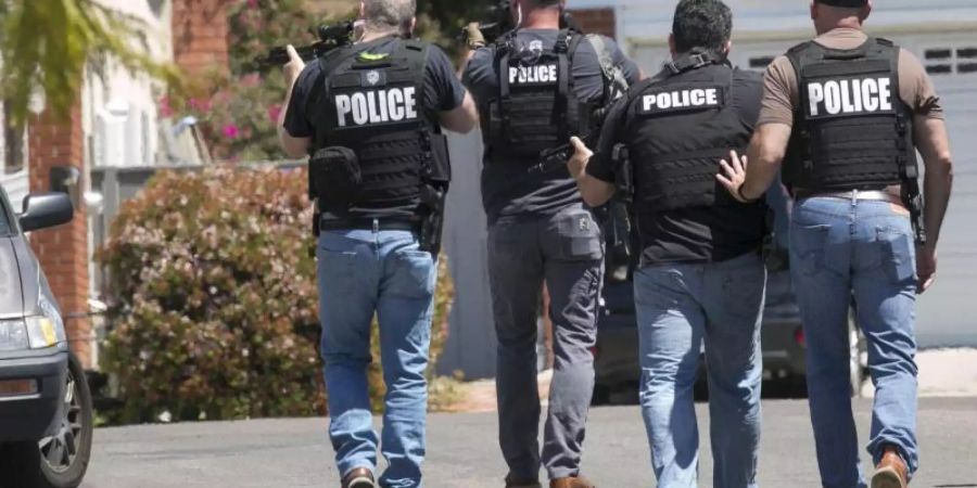 Schwer bewaffnete Polizisten aus San Diego nähern sich einem Haus, in dem der Täter eines Anschlags auf die Chabad of Poway Synagoge vermutet wird. Foto: John Gibbins/The San Diego Union-Tribune/AP