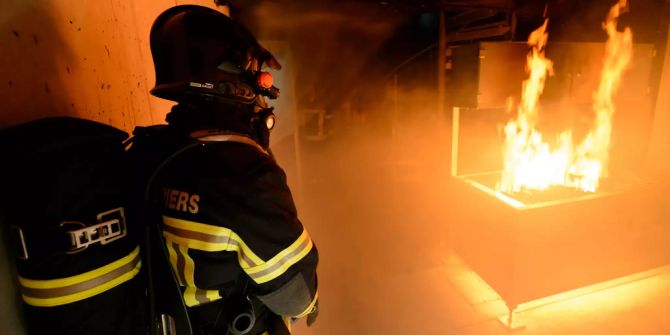 Ein Mitglied der Feuerwehr löscht ein Feuer.