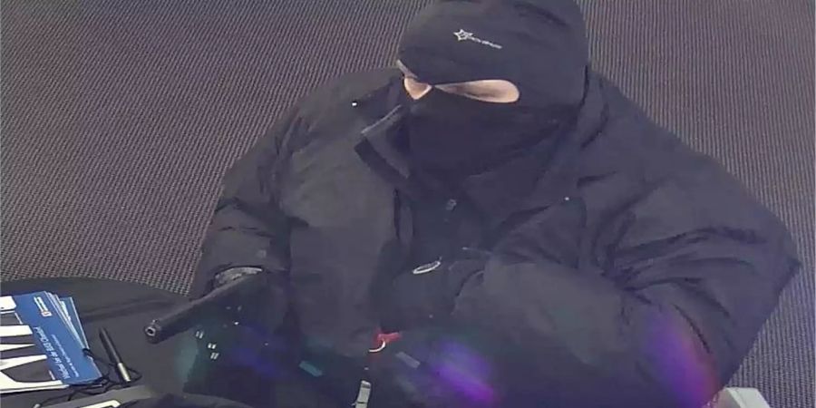 Vermummter Mann droht mit Waffe in einer Bank