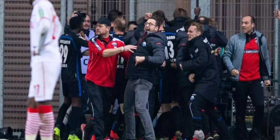 Kölns Anthony Modeste kann nur staunen: Die Paderborner feiern den späten 3:2-Sieg. Foto: Guido Kirchner