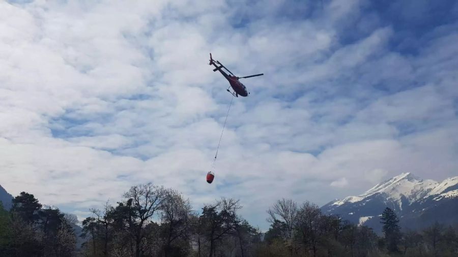 Der Helikopter fliegt mit dem gefüllten Wassersack.