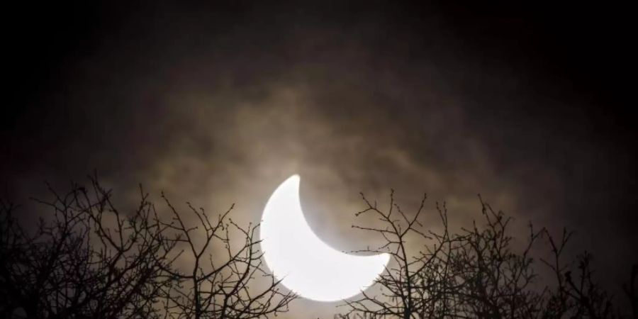Der Mond hat sich vor die Sonne geschoben. Erstmals seit sechs Jahren ist am 10. Juni über Deutschland wieder eine partielle Sonnenfinsternis zu sehen. Foto: Olivier Maire/KEYSTONE/epa/dpa