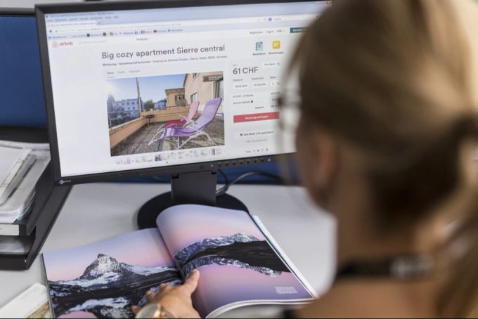 Eine Frau sieht sich eine Unterkunft auf Airbnb an. Airbnb