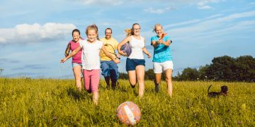 Familie rennt hinter Ball her