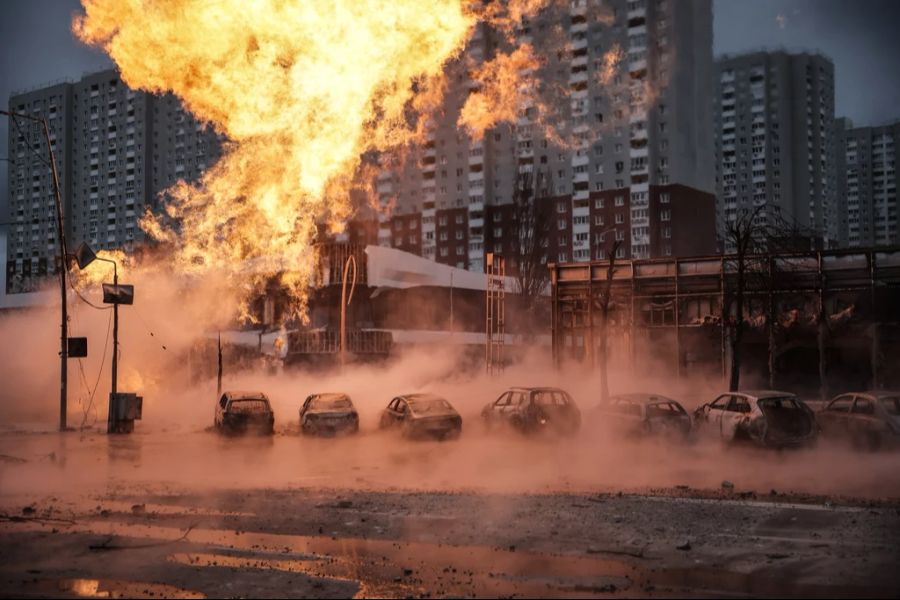 Blick auf ein Feuer in der Nähe eines Autohauses nach einem Raketeneinschlag in Kiew.