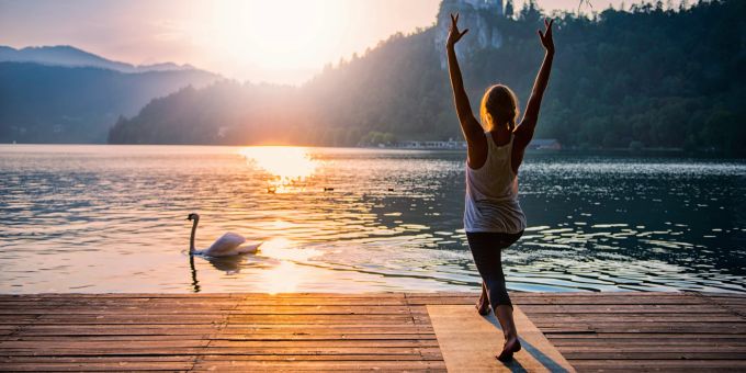 Ob mit oder ohne See: Der Sonnengruss ist ein guter Einstieg in die jede Yoga-Praxis. See Schwan Frau Yoga
