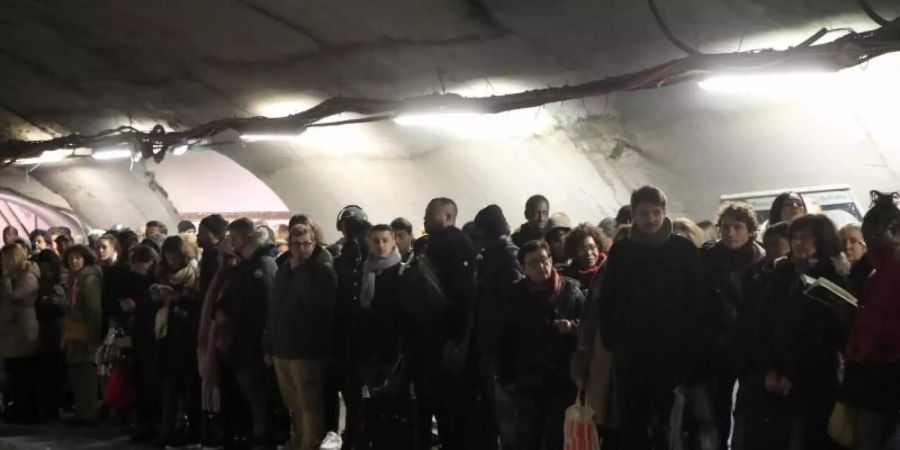 Pendler warten an einem Bahnsteig in Paris vergeblich auf eine U-Bahn. Foto: Michel Euler/AP/dpa