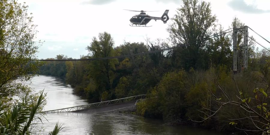Ein Helikopter fliegt über die eingestürzte Brücke am Fluss Tarn.