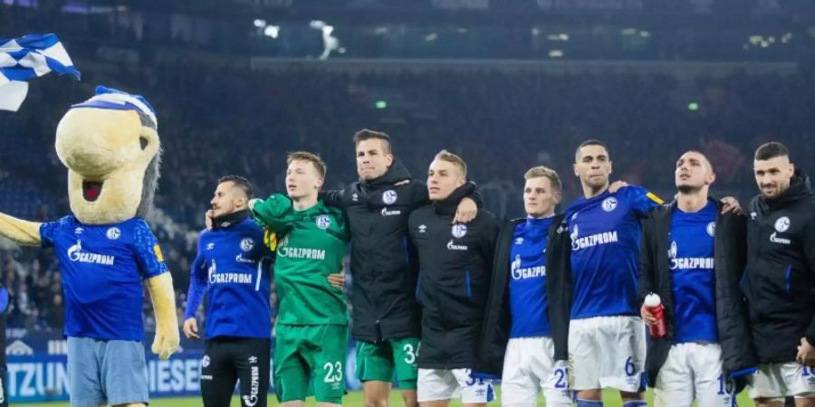 Arm in Arm in die Winterpause: Schalkes Profis feiern nach dem 2:2 gegen Freiburg mit ihren Fans. Foto: Rolf Vennenbernd/dpa