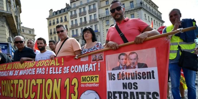 Demonstranten wehren sich gegen die geplante Rentenreform in Frankreich: «Sie zerstören unsere Renten», steht auf einem Banner unter einem Bild des Präsidenten Macron. rentenreform frankreich