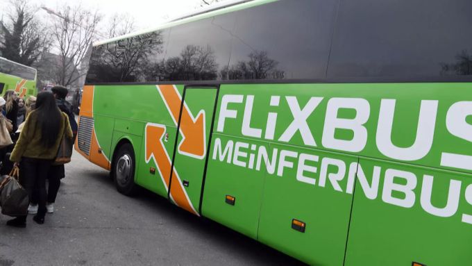 Reisende stehen vor einem Flixbus. Flixbus