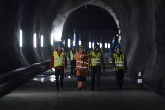 Bauarbeiter laufen im Rohbau Richtung Ferden im Lötschberg Basistunnel, am Dienstag, 13. November 2018, in Frutigen. lötschberg