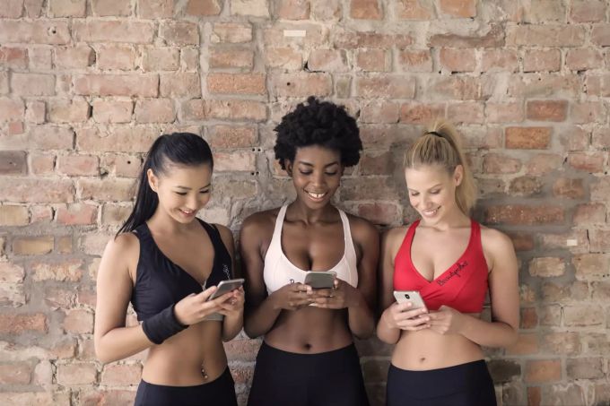 Telefonate sollten besser nicht im Trainingsraum geführt werden. Drei Frauen am Handy