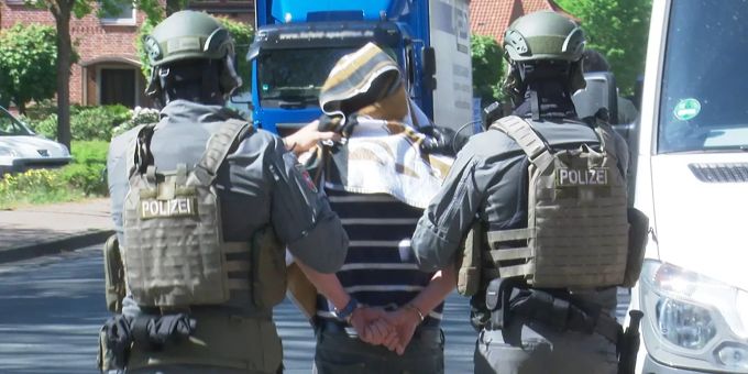 Polizisten führen nach einem Polizeieinsatz einen Verdächtigen in Handschellen ab. Rund sieben Monate nach seinem vermeintlichen Ertrinken in der Ostsee haben Ermittler einen 52-jährigen Kieler in Niedersachsen (D) ausfindig gemacht. Festnahme von Versicherungsbetrüger