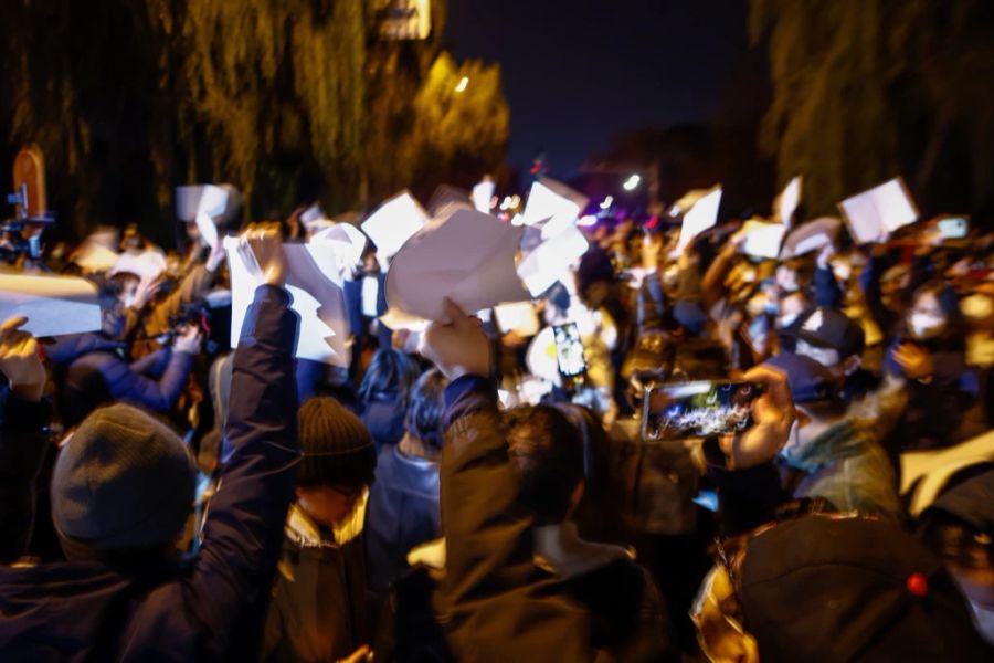 Als Protest gegen die Zensur in China halten Demonstranten in Shanghai ein weisses Blatt in die Höhe.