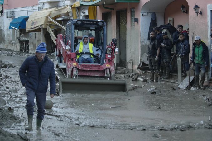 Einsatzkräfte versuchen, die Schlammmassen aus dem Dorfzentrum wegzuschaufeln. Italy Landslide