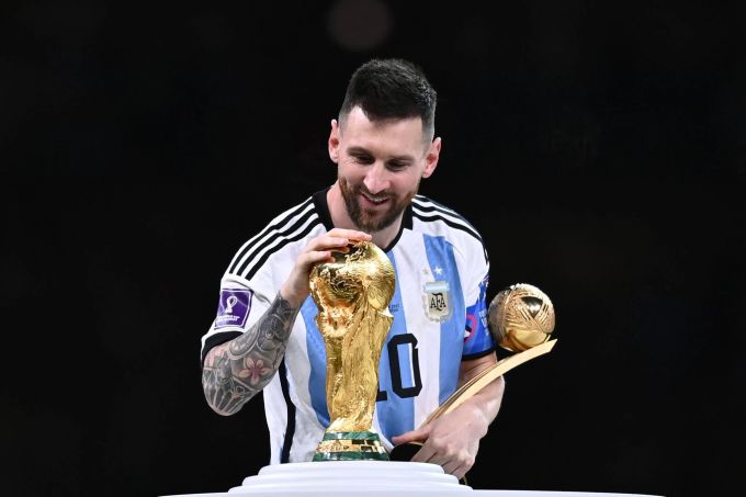 Lionel Messi jubelt an der WM 2022 mit dem Pokal und der Trophäe für den besten Spieler. Lionel Messi WM 2022