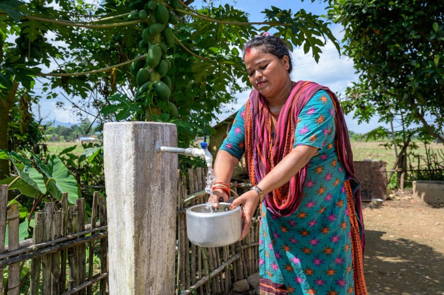 Mina Bishwakarma füllt eine Schüssel mit Trinkwasser auf.