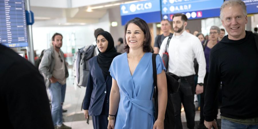 Aussenministerin Annalena Baerbock (M, Bündnis 90/Die Grünen) ist auf dem Flughafen in Dubai auf dem Weg zu ihrem Flug.