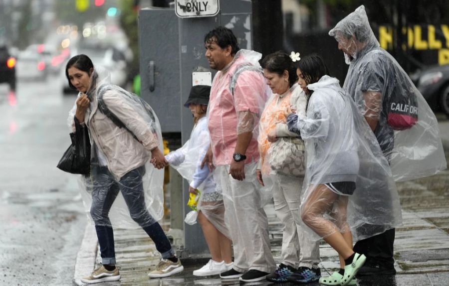 Menschen kämpfen in Los Angeles gegen Wind und Regen.