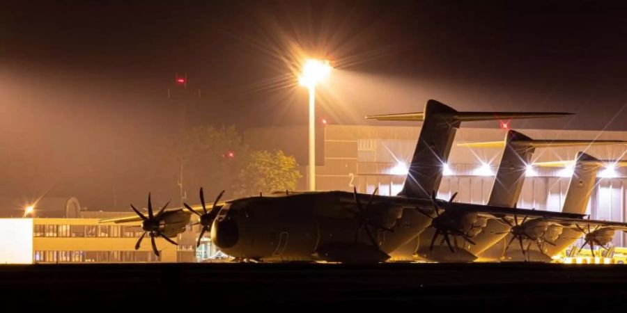 Transportflugzeuge vom Typ Airbus A400M der Luftwaffe stehen am Abend auf dem Fliegerhorst Wunstorf in der Region Hannover hinter einem Zaun. Foto: Moritz Frankenberg/dpa