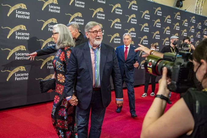 Schauspieler John Landis (mitte) mit seiner Frau Deborah Nadoolman (l) aus den USA auf der Piazza Grande beim 74. Internationalen Filmfestival Locarno in Locarno, Schweiz, am 13. August 2021. john landis