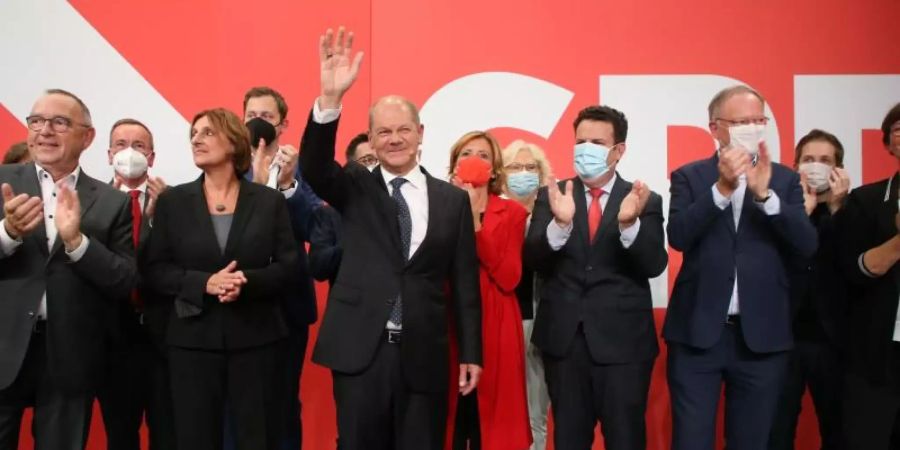 Olaf Scholz (M) hat auf der Wahlparty im Willy-Brandt-Haus Grund zur Freude. Foto: Wolfgang Kumm/dpa