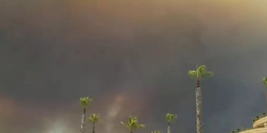 Dunkler Rauch zieht über einen Hotelkompex in der türkischen Urlaubsregion Antalya hinweg. Winde trieben die Flammen mehrerer Waldbrände in Richtung der Wohnbezirke, wie der Landrat des Bezirks Manavgat dem Sender CNN Türk sagte. Foto: Cevin Dettlaff/dpa-Zentralbild/dpa