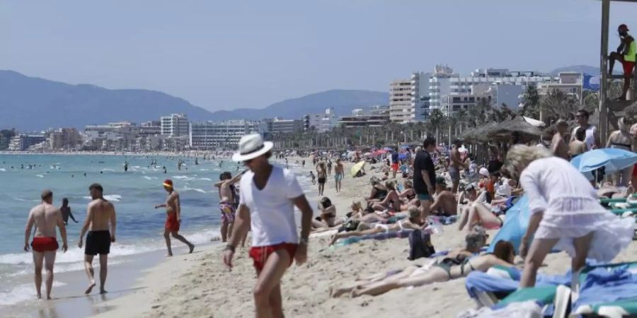 Touristen am Strand von Arenal in Palma de Mallorca auf. Foto: Clara Margais/dpa